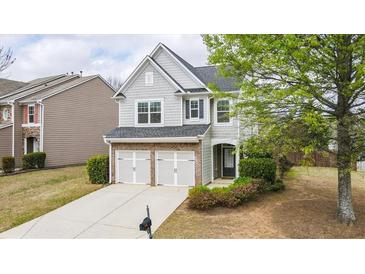 Charming two-story home with a well-maintained lawn, brick accents, and a two-car garage at 5510 Weddington Dr, Cumming, GA 30040