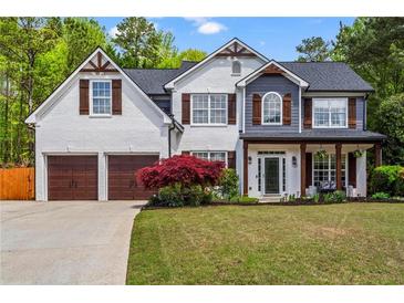 Charming two-story home with a manicured lawn, inviting front porch, and a two-car garage at 904 Beaumont Ct, Canton, GA 30114