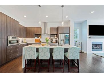 Modern kitchen featuring an island with seating, stainless steel appliances, and stylish pendant lighting at 1388 La France Ne St, Atlanta, GA 30307