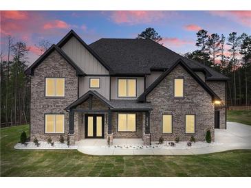 Charming two-story home featuring a brick facade, covered entrance, and well-manicured lawn at 2107 E Maddox Rd, Buford, GA 30519