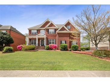 Beautiful two-story brick home with well-manicured lawn and colorful landscaping at 295 Langshire Dr, Mcdonough, GA 30253