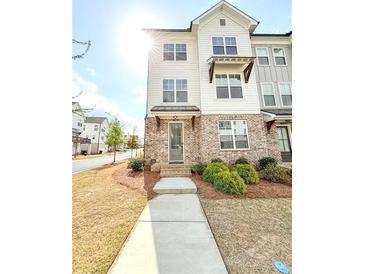 Charming three-story townhouse with brick accents and well-maintained landscaping at 1166 Farmstead Rd, Suwanee, GA 30024