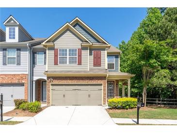 Charming townhouse with a two-car garage, manicured lawn, and inviting curb appeal at 2436 Sardis Chase Ct, Buford, GA 30519
