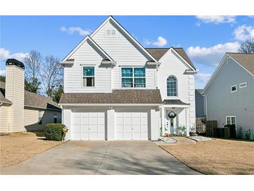 Charming two-story home features a two-car garage, white siding, and a well-maintained front yard in a desirable location at 1240 Birchwood Ln, Roswell, GA 30076