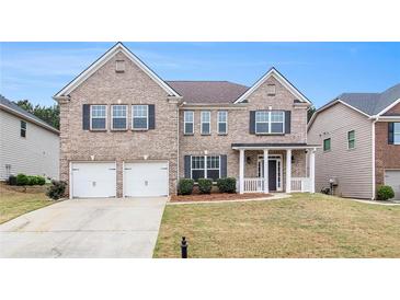 Charming two-story brick home with a well-manicured lawn, two-car garage, and inviting front porch at 2036 Broadmoor Way, Fairburn, GA 30213