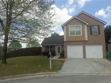 Charming two-story home featuring a brick facade, a two-car garage, and a well-maintained front lawn at 1325 Sandlewood Ct, Lithonia, GA 30058