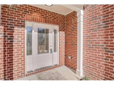 Inviting front entrance with decorative glass door and classic red brick facade at 4066 Wild Orchid Ln, Loganville, GA 30052