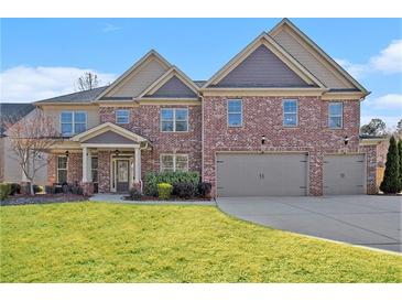 Stately two-story brick home featuring a two-car garage and well-manicured lawn at 4922 Summer Wind Dr, Buford, GA 30519