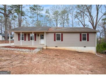 Charming single-story home featuring vinyl siding, covered entry porch, and mature trees surrounding the property at 5700 Tracy Dr, Mableton, GA 30126