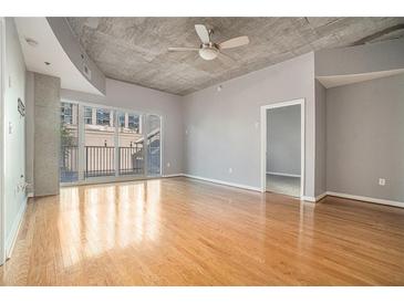 Bright living room with hardwood floors, concrete ceiling, and balcony access at 250 Pharr Ne Rd, Atlanta, GA 30305