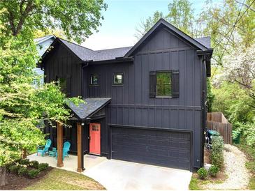 Modern two-story home with a welcoming porch, an attached garage, and a vibrant coral front door at 3172 Chapel St, Scottdale, GA 30079