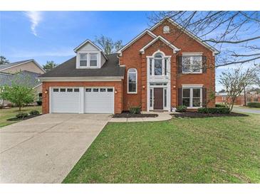 Charming two-story brick home with a well-manicured lawn and a two-car garage at 2500 Grand Manor Ct, Marietta, GA 30068