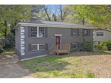 Charming two-story home with a brick facade and a cozy front porch, set amidst lush greenery and mature trees at 149 Roy Huie Rd, Riverdale, GA 30274
