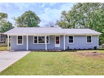 Charming one-story home with a well-manicured lawn, gray brick, and a welcoming red front door at 5251 Joan Of Arc Pl, Atlanta, GA 30349