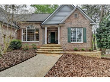 Charming brick home featuring a stone walkway, well-maintained landscaping, and a welcoming front entrance at 3230 Riverhill Ct, Cumming, GA 30041