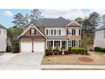 Beautiful two-story home with manicured lawn, a two car garage and covered front porch entry at 4495 Alister Park Dr, Cumming, GA 30040