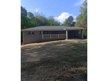 A single story home with a white picket fence, attached carport and green lawn at 2598 Miriam Ln, Decatur, GA 30032