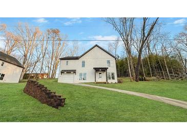 Charming two-story home with landscaped front yard, stone retaining wall, and private driveway at 5215 Virginia Ave, Cumming, GA 30041