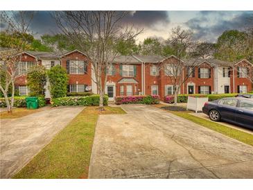 Charming brick townhomes with landscaped front yards and individual parking spaces at 5587 Strathmoor Manor Cir, Lithonia, GA 30058