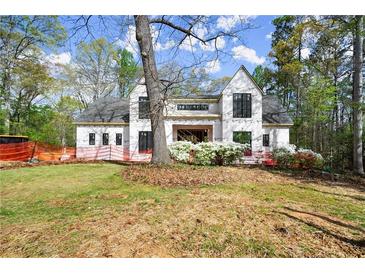 New home boasts modern design, black-trimmed windows, a manicured lawn, and blooming flowers at 1430 Oconee Ne Pass, Brookhaven, GA 30319