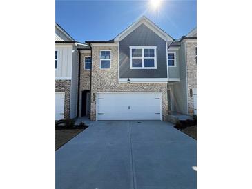 Charming brick townhome with a two-car garage, well-maintained landscaping, and inviting curb appeal at 5645 Hislop Ln # 89, Mableton, GA 30126