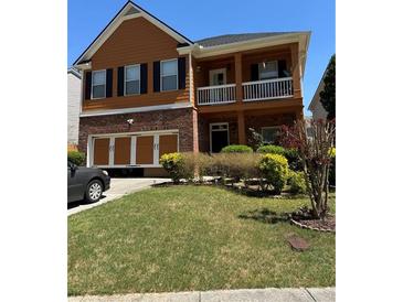 Charming two-story home with brick accents, an attached garage, and a cozy second-story balcony at 1668 Scenic Pines Dr, Lawrenceville, GA 30044
