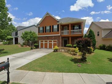 Charming two-story home with a balcony, brick accents, and well-maintained landscaping at 1668 Scenic Pines Dr, Lawrenceville, GA 30044