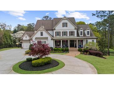 Inviting two-story traditional home with manicured lawn, circular driveway, and a charming front porch at 332 Chaffin Rd, Roswell, GA 30075