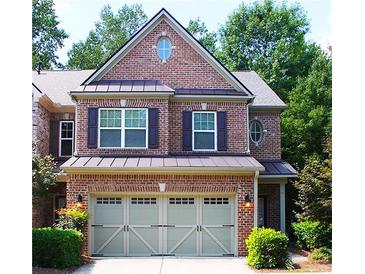 Charming two-story brick home featuring a well-manicured lawn and an attached two-car garage at 11212 Snowy Owl Ln, Alpharetta, GA 30022