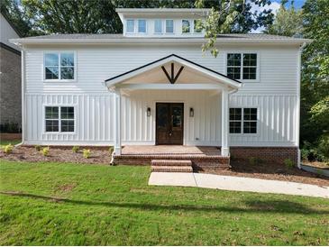 Charming new construction home featuring a classic design, a covered porch, and a well-manicured lawn at 2438 Shadburn Ferry Dr, Buford, GA 30518