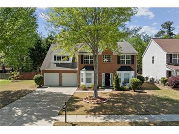 Charming two-story brick home with a two-car garage, landscaped yard, and classic black shutters at 3452 Hard Creek Ln, Buford, GA 30519