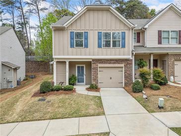 Charming townhome with stone accents, blue shutters, and a one-car garage at 114 Oakview Psge, Canton, GA 30114