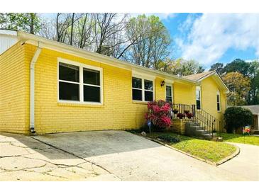 Charming yellow brick home featuring a concrete driveway and well-maintained front yard at 4554 Saint Andrews Dr, Atlanta, GA 30331