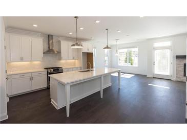 Bright kitchen with white cabinets, stainless appliances, and large center island with marble countertop at 702 Dodd Ln # 159, Buford, GA 30518