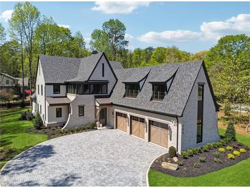 Stunning brick home featuring a three-car garage and a beautifully paved driveway at 100 Maison Ct, Roswell, GA 30076