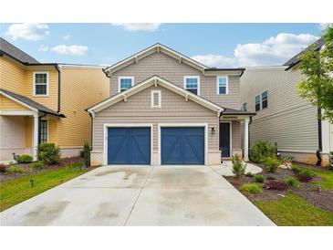Charming two-story home featuring a two-car garage, manicured landscaping, and inviting curb appeal at 4143 Halton Rd, Duluth, GA 30097
