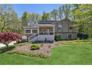 Charming exterior features a covered front porch, well-manicured lawn, and beautiful landscaping at 5533 Woodridge Ln, Douglasville, GA 30135