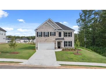 Beautiful two-story home with a well-manicured lawn, attached garage and classic architectural features at 1119 Blue Juniper Circle, Loganville, GA 30052