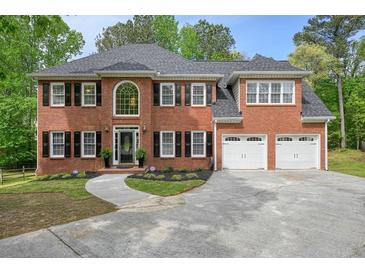 Charming two-story brick home featuring a two-car garage and manicured landscaping at 3130 Crestmont Nw Way, Kennesaw, GA 30152