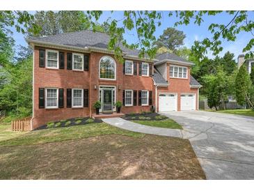 Charming two-story red brick home with a well-manicured lawn, black shutters and a two car garage at 3130 Crestmont Nw Way, Kennesaw, GA 30152
