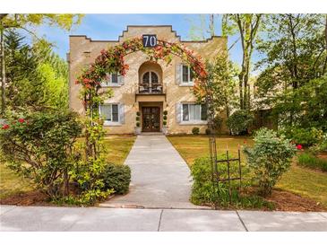 Charming stucco home with lush landscaping and a welcoming floral archway over the entrance at 70 Sheridan Ne Dr # 10, Atlanta, GA 30305