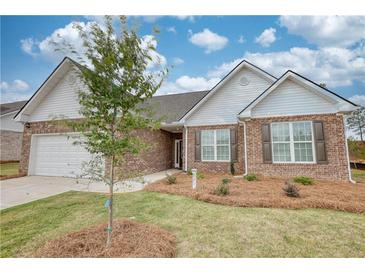 Charming single-story brick home with a well-manicured lawn and a two-car garage at 711 Park Place Way, Social Circle, GA 30025
