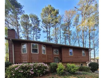 Charming split-level home with lovely landscaping and flowering shrubs in front yard at 4149 Silver Hill Ct, Snellville, GA 30039