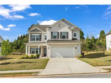 Charming two-story home with a brick facade, black shutters, attached two car garage and well maintained lawn at 5140 Woodline View Cir, Auburn, GA 30011
