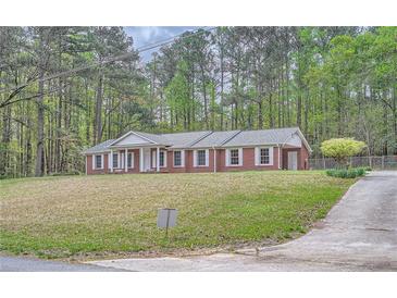 Quaint one-story brick home nestled on a hill with traditional white columns and shutters at 6435 E Glen Rd, Lithonia, GA 30038