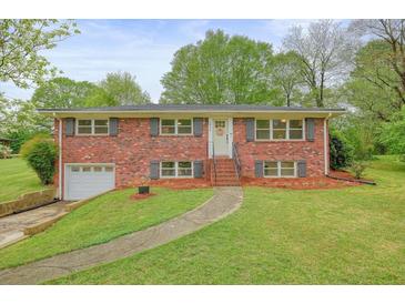 Traditional brick home with a well-maintained lawn and mature trees at 2449 Fraser Rd, Marietta, GA 30066