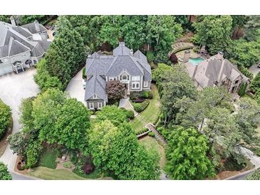 Stunning aerial view of a luxurious home surrounded by lush greenery, showcasing its grand architecture at 3915 Merriweather Woods, Johns Creek, GA 30022