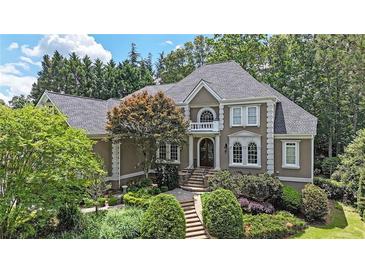 Stately two-story home with mature landscaping, a walkway, and elegant architectural details at 3915 Merriweather Woods, Johns Creek, GA 30022