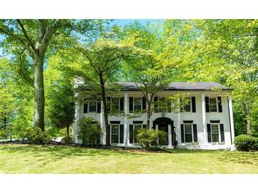 Charming two-story white home featuring a black roof, black shutters and a beautiful lawn at 909 Otter Ne Way, Marietta, GA 30068