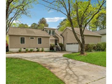 Charming home featuring a driveway, attached garage, and well-manicured front lawn with mature trees at 2470 Woodmere Dr, Marietta, GA 30068